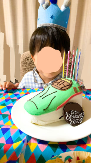 ローソクとチョコプレートを飾った新幹線はやぶさのケーキと息子です